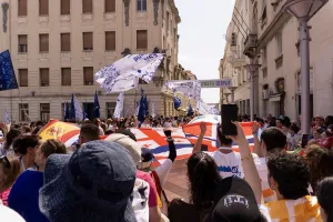 people marching in a parade holding flags of different countries