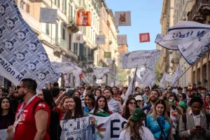 People marching in a parade holding flags of different countries