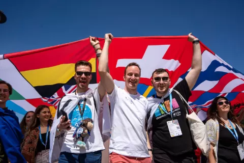 A group of young people carrying different country flags